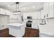 Bright kitchen features white cabinets, stainless steel appliances, and a spacious island with quartz countertop at 5745 Snapdragon Ln, Huntersville, NC 28078