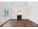Bright living room with a fireplace, hardwood floors and large windows offer ample light and scenic views at 5745 Snapdragon Ln, Huntersville, NC 28078