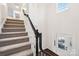 Carpeted staircase with white and dark wood trim and a glass-paneled front door at 5745 Snapdragon Ln, Huntersville, NC 28078