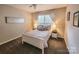 Carpeted bedroom featuring a queen bed, lamps, closet, and natural light at 6231 Kentwood Dr, Kannapolis, NC 28081