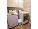 Bright laundry room featuring white washer and dryer, storage cabinets, and wire shelving at 6231 Kentwood Dr, Kannapolis, NC 28081