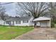 Charming single-story home featuring a carport, well-maintained lawn, and a welcoming entryway with iron railings at 6323 Wilora Lake Rd, Charlotte, NC 28212