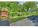 Lush backyard featuring a playset, patio seating, and a well-manicured lawn at 6618 Vizcaya Ct, Charlotte, NC 28226