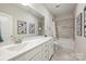 Bright bathroom featuring a white double sink vanity, a large mirror, and a shower with a tub at 6618 Vizcaya Ct, Charlotte, NC 28226
