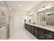 A modern bathroom features a double sink vanity, dark wood cabinets, granite countertop and a glass-enclosed shower at 6618 Vizcaya Ct, Charlotte, NC 28226