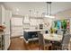 Bright kitchen features white cabinetry, an island with bar seating, and a dining table for casual meals at 6618 Vizcaya Ct, Charlotte, NC 28226