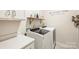 Modern laundry room features white cabinets, shelving and a front-load washer and dryer at 6618 Vizcaya Ct, Charlotte, NC 28226