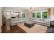 Bright living room featuring a large sectional sofa, hardwood floors, and backyard views at 6618 Vizcaya Ct, Charlotte, NC 28226