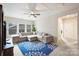 Bright living room with a large sectional sofa, a ceiling fan, and three windows overlooking the backyard at 6618 Vizcaya Ct, Charlotte, NC 28226