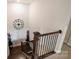 Staircase with dark wood railing and white walls, leading to the lower level at 6618 Vizcaya Ct, Charlotte, NC 28226