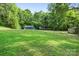 A home nestled within nature with a large backyard featuring green grass, mature trees, and an RV at 715 Potneck Rd, Salisbury, NC 28147
