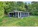 Exterior view of home with a screened sunroom, a lean-to, and large grassy yard at 715 Potneck Rd, Salisbury, NC 28147