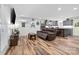 Open-concept living room flows into the kitchen, featuring a comfortable leather recliner and wood-look floors at 715 Potneck Rd, Salisbury, NC 28147