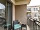 Cozy balcony features a comfortable chair with a blue cushion and a small table at 718 W Trade St # 704, Charlotte, NC 28202