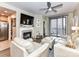 Neutral living room with modern fireplace, TV, fan, balcony and leather furniture with ottoman at 718 W Trade St # 704, Charlotte, NC 28202
