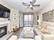Neutral living room with modern fireplace, TV, fan, balcony and leather furniture with ottoman at 718 W Trade St # 704, Charlotte, NC 28202