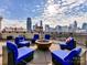 Breathtaking city skyline view with comfortable seating around the fire pit on the roof top deck at 718 W Trade St # 704, Charlotte, NC 28202