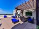 The rooftop deck has a grill, dining table and pergola covered seating area with exterior decoration at 718 W Trade St # 704, Charlotte, NC 28202
