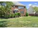 Spacious backyard with lush green lawn, brick house, and deck, perfect for outdoor activities at 7525 Blackgum Falls Ct, Huntersville, NC 28078