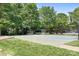 Outdoor basketball court surrounded by green grass and shade trees at 7525 Blackgum Falls Ct, Huntersville, NC 28078