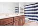 Bathroom featuring double sinks, wood cabinets, and a striped shower curtain at 7525 Blackgum Falls Ct, Huntersville, NC 28078