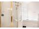A bright bathroom featuring a glass-enclosed shower, a separate soaking tub, and tiled walls at 7525 Blackgum Falls Ct, Huntersville, NC 28078