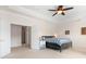 Spacious bedroom featuring a ceiling fan, tray ceilings, and neutral decor at 7525 Blackgum Falls Ct, Huntersville, NC 28078