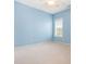 A light blue bedroom with a window and beige carpet at 7525 Blackgum Falls Ct, Huntersville, NC 28078