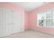 A pink bedroom featuring a window, closet and white carpet at 7525 Blackgum Falls Ct, Huntersville, NC 28078