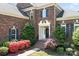 Elegant brick home featuring decorative shutters, flowering bushes and a grand entryway at 7525 Blackgum Falls Ct, Huntersville, NC 28078