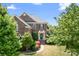 Charming brick home featuring lush landscaping, a welcoming entrance, and mature trees on a sunny day at 7525 Blackgum Falls Ct, Huntersville, NC 28078