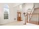Grand two-story foyer featuring a decorative front door, staircase, and natural light at 7525 Blackgum Falls Ct, Huntersville, NC 28078
