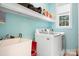 A laundry room with a utility sink, a front-load washer and dryer, and storage shelves at 7525 Blackgum Falls Ct, Huntersville, NC 28078