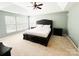 Bedroom with a dark-colored bed, carpet flooring, and windows allowing natural light at 8218 Lynnewood Glen Dr, Charlotte, NC 28269