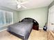 This bedroom has neutral colored walls, carpeted floor, a ceiling fan, and a large window at 8218 Lynnewood Glen Dr, Charlotte, NC 28269