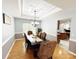 Elegant dining room with hardwood floors, decorative chandelier, and an adjacent kitchen at 8218 Lynnewood Glen Dr, Charlotte, NC 28269