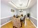 Elegant dining room featuring a tray ceiling, hardwood floors, and a chandelier above a wooden table at 8218 Lynnewood Glen Dr, Charlotte, NC 28269