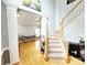 Bright foyer with hardwood floors, staircase, and decorative columns leading to a living area with a hammock at 8218 Lynnewood Glen Dr, Charlotte, NC 28269