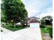 Lovely two-story brick home with manicured lawn, tree, and an attached two-car garage with long driveway at 8218 Lynnewood Glen Dr, Charlotte, NC 28269
