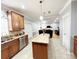 Bright kitchen with stainless steel appliances, granite counters, an island, and an adjacent living area at 8218 Lynnewood Glen Dr, Charlotte, NC 28269