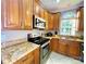 Close-up of a kitchen featuring granite countertops, stainless steel appliances, and wooden cabinetry at 8218 Lynnewood Glen Dr, Charlotte, NC 28269
