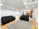 Inviting living room featuring hardwood floors, tray ceiling, neutral paint, and an adjacent kitchen at 8218 Lynnewood Glen Dr, Charlotte, NC 28269