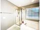 The main bathroom has a tub/shower with a glass door and a large window to let in natural light at 8218 Lynnewood Glen Dr, Charlotte, NC 28269