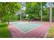 Backyard with a combined sport court for basketball and tennis, surrounded by lush greenery and trees at 8707 Fairview Rd, Charlotte, NC 28226