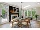 Bright dining room with a glass-top table, modern lighting, and a decorative fireplace accent wall at 8707 Fairview Rd, Charlotte, NC 28226