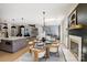 Open dining area featuring a glass-top table, fireplace, and views to the kitchen and living spaces at 8707 Fairview Rd, Charlotte, NC 28226