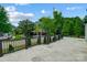 Beautiful home exterior featuring a large deck, manicured landscaping, and a glimpse of the driveway at 8707 Fairview Rd, Charlotte, NC 28226