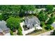 Aerial back view of the home showing the rear patio, yard and basketball court in the landscaping at 8707 Fairview Rd, Charlotte, NC 28226