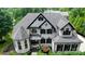 Stunning two-story home featuring a gray roof, white brick, black shutters and meticulously manicured landscaping at 8707 Fairview Rd, Charlotte, NC 28226