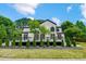 Rear exterior of a two-story white brick home featuring a patio and manicured landscaping at 8707 Fairview Rd, Charlotte, NC 28226